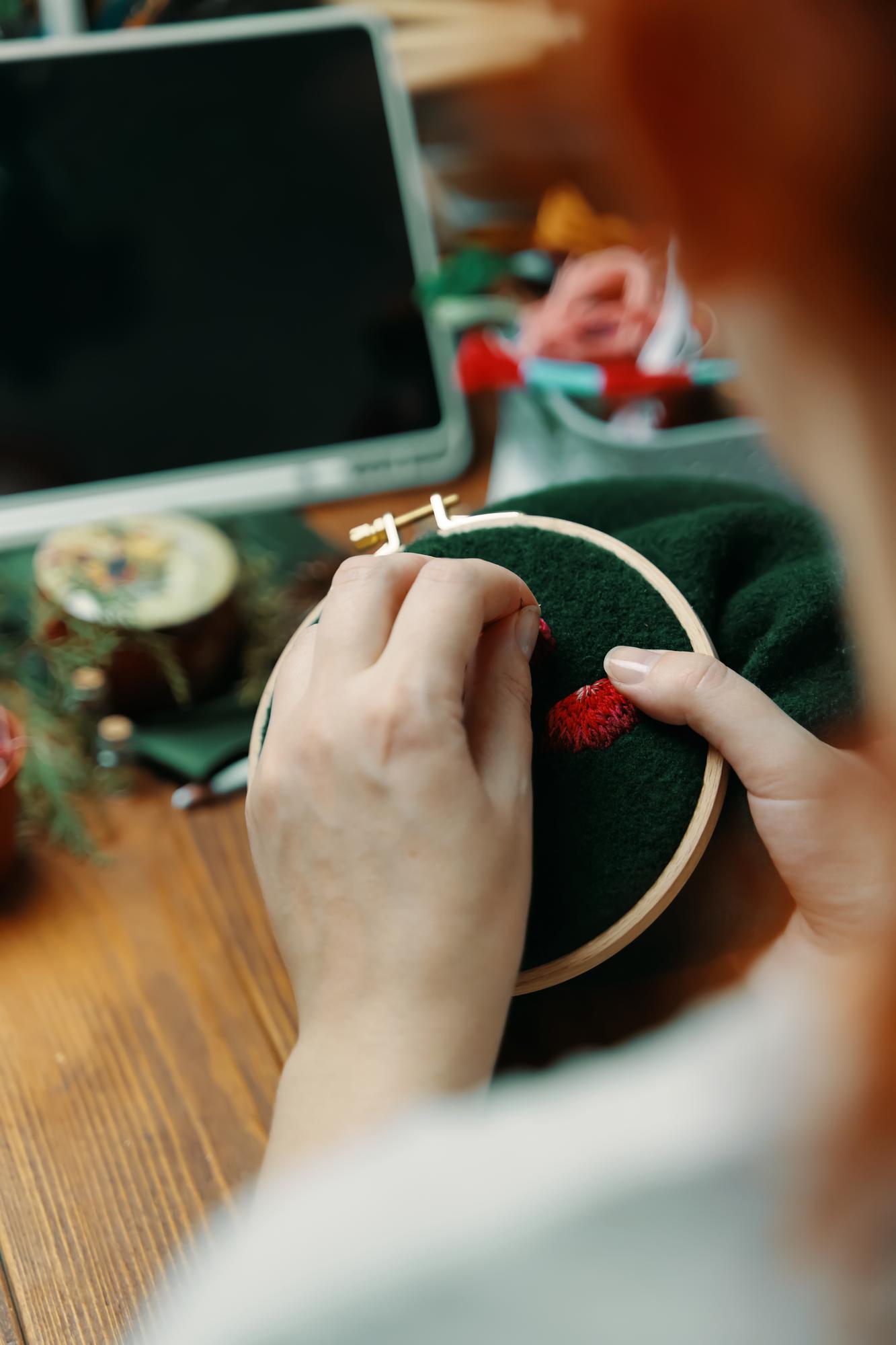 Teacher demonstrating embroidery stitches in studio