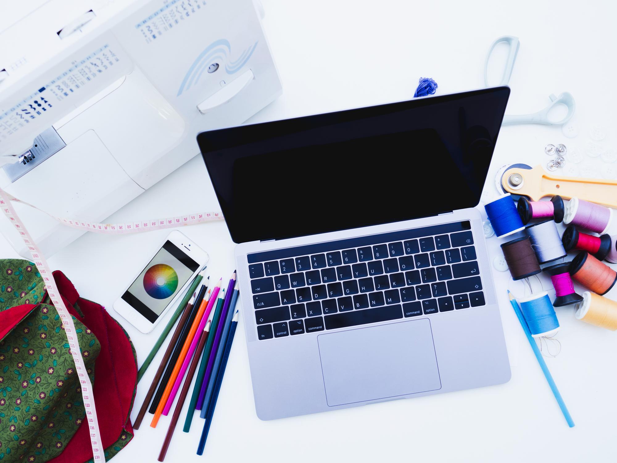 Laptop with embroidery pattern on screen and modern tools